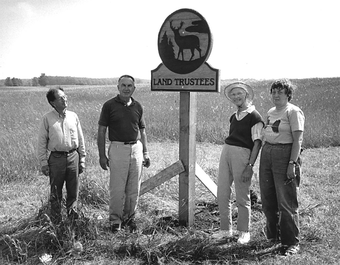 Founding Door County Land Trustees standing by the original Land Trustees sign, 1986